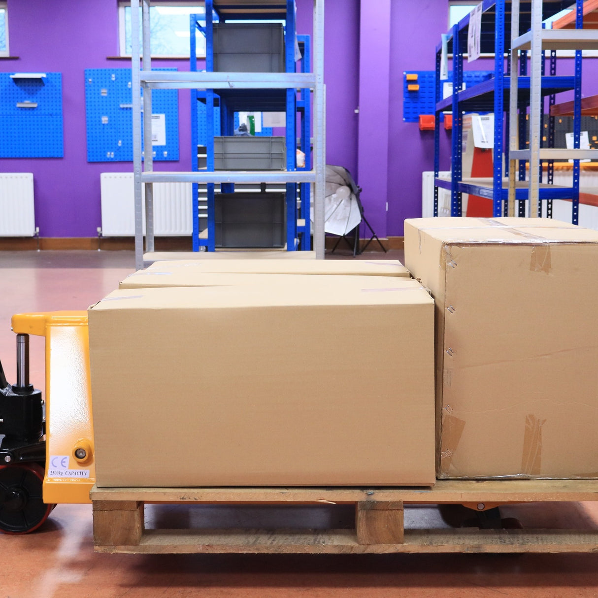 Three large boxes on a pallet, ready for RackZone 2500kg PU Pallet Truck.