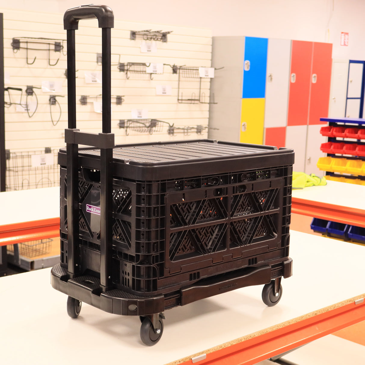 A RackZone Foldable Picking Crate Dolly c/w Handle 48L is by the lockers.