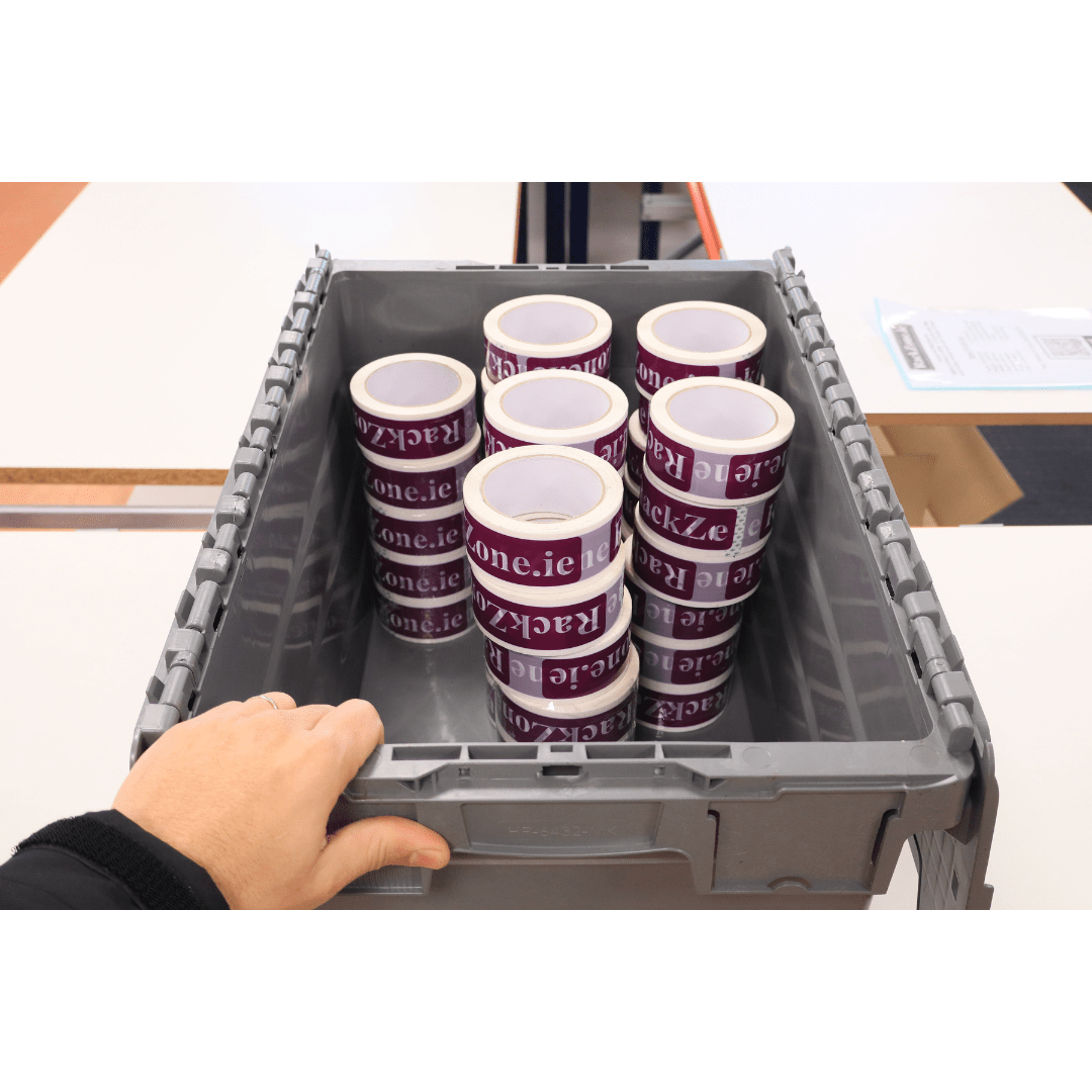 A hand holds a RackZone 58L grey attached lid container with branded tape.