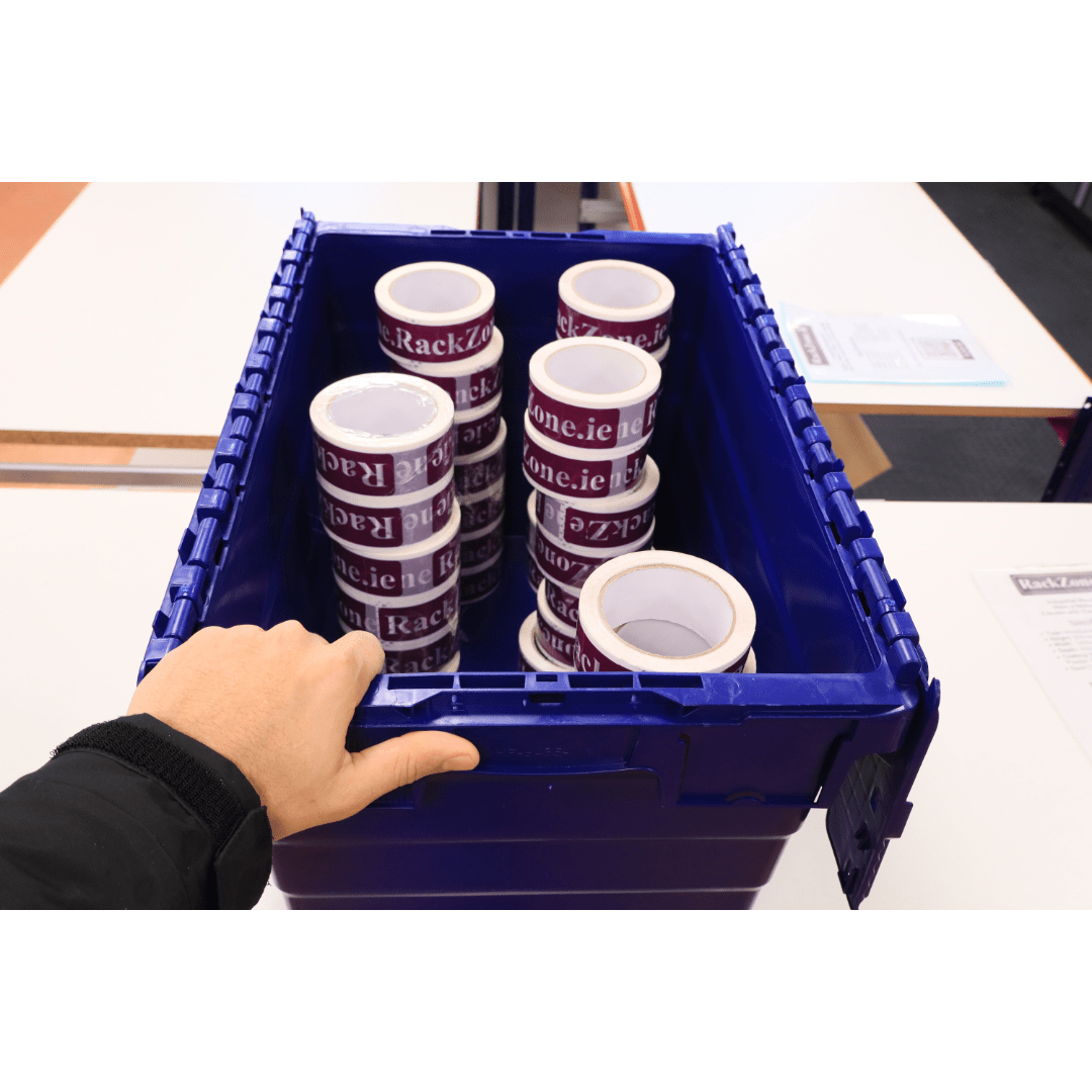 A hand holds a blue RackZone 66L container filled with packaging tape rolls.