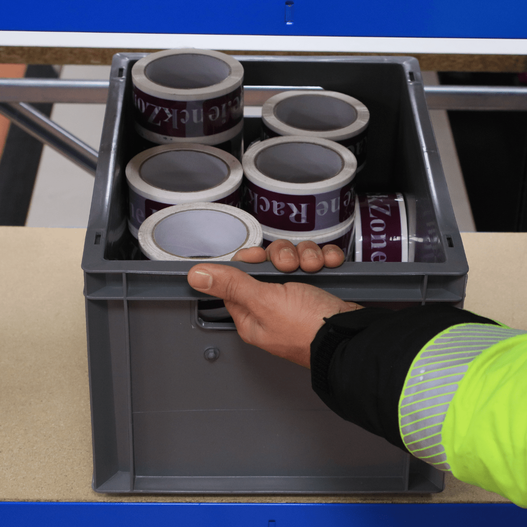 Someone places a RackZone Euro Container 400x300x220mm Grey on a table.