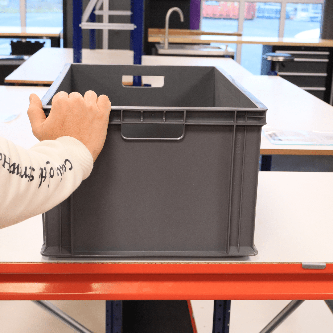 A person places a hand on a RackZone Euro Container 600x400x280mm Grey.