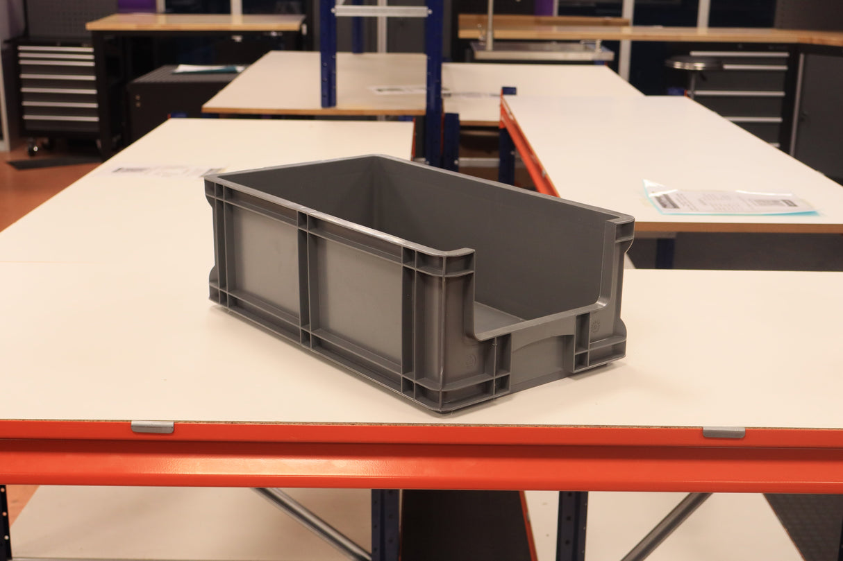 A RackZone grey Euro Picking Container is on a white worktable in a workshop.