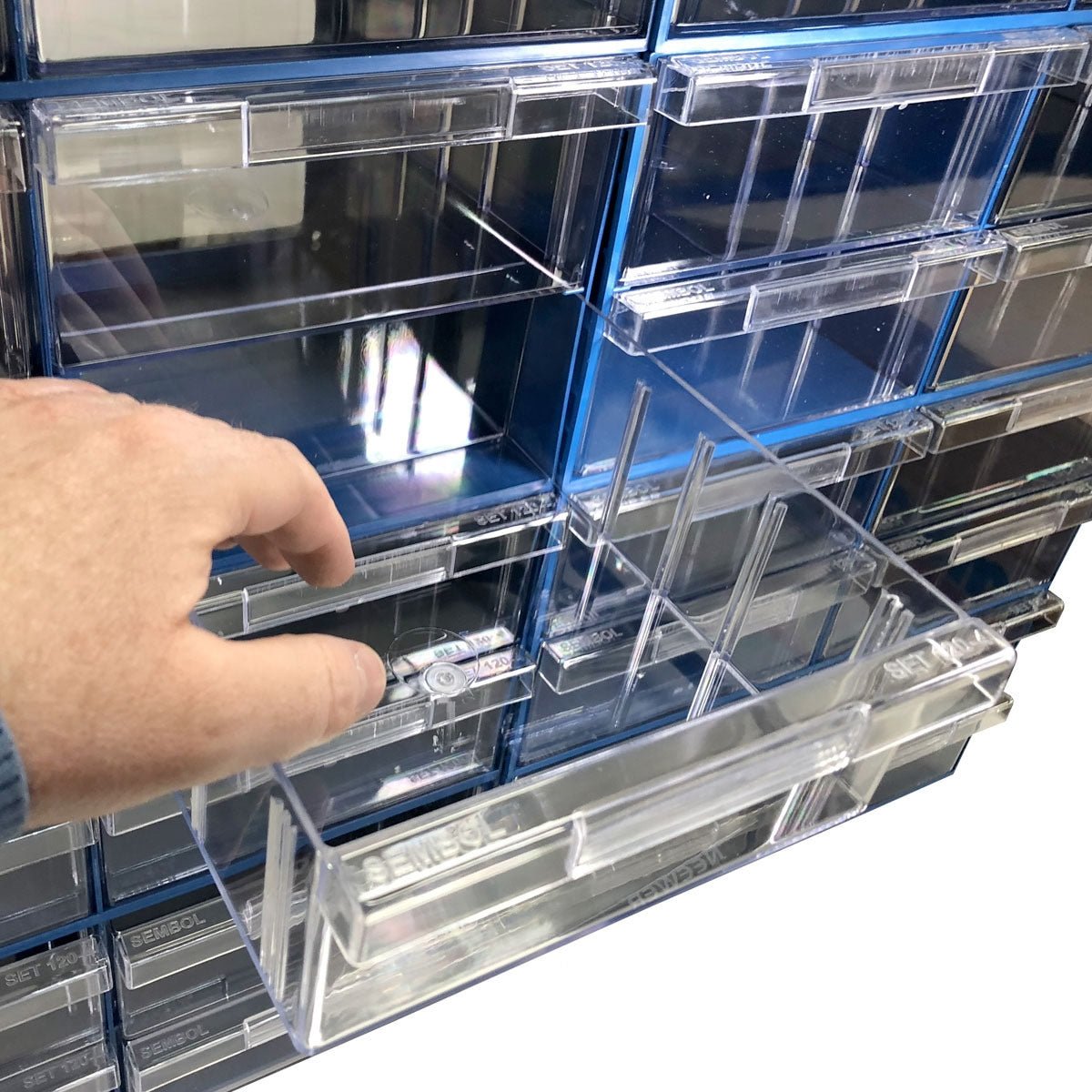 A hand pulls open a drawer in the RackZone Plastic Drawer 32 Box organizer.