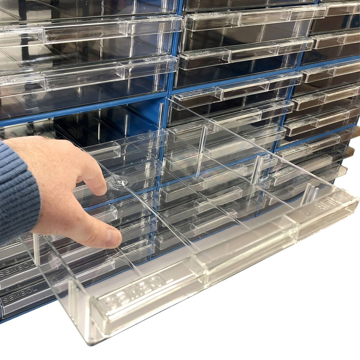 A hand pulls a RackZone Plastic Drawer 36 Box from a stack of clear containers.
