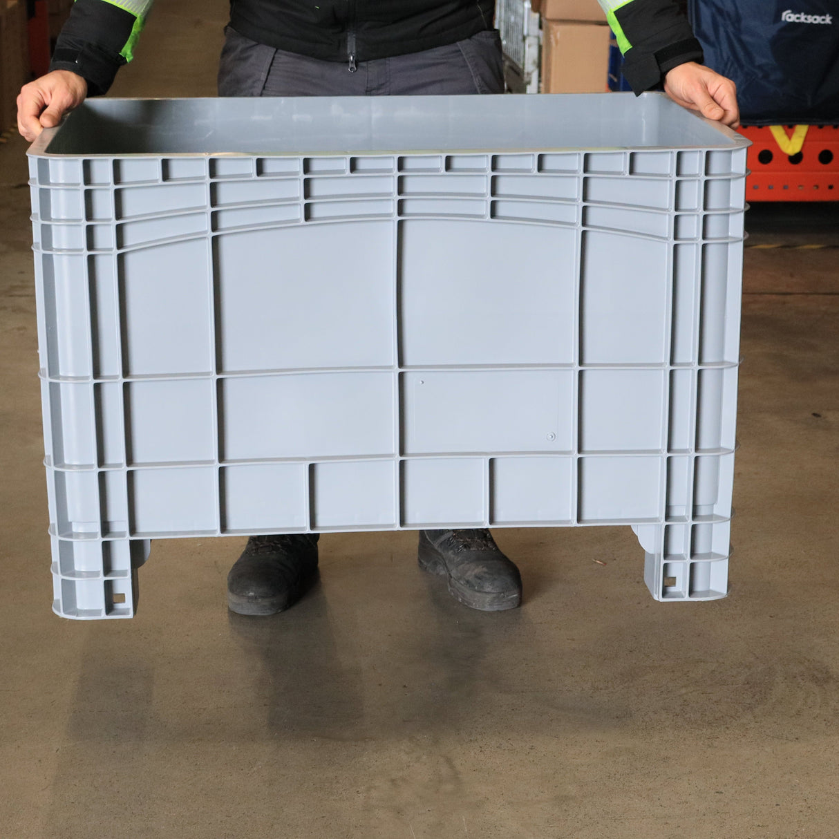 Person holding a RackZone Stacking Container 984d x 625w x 665h Grey indoors.