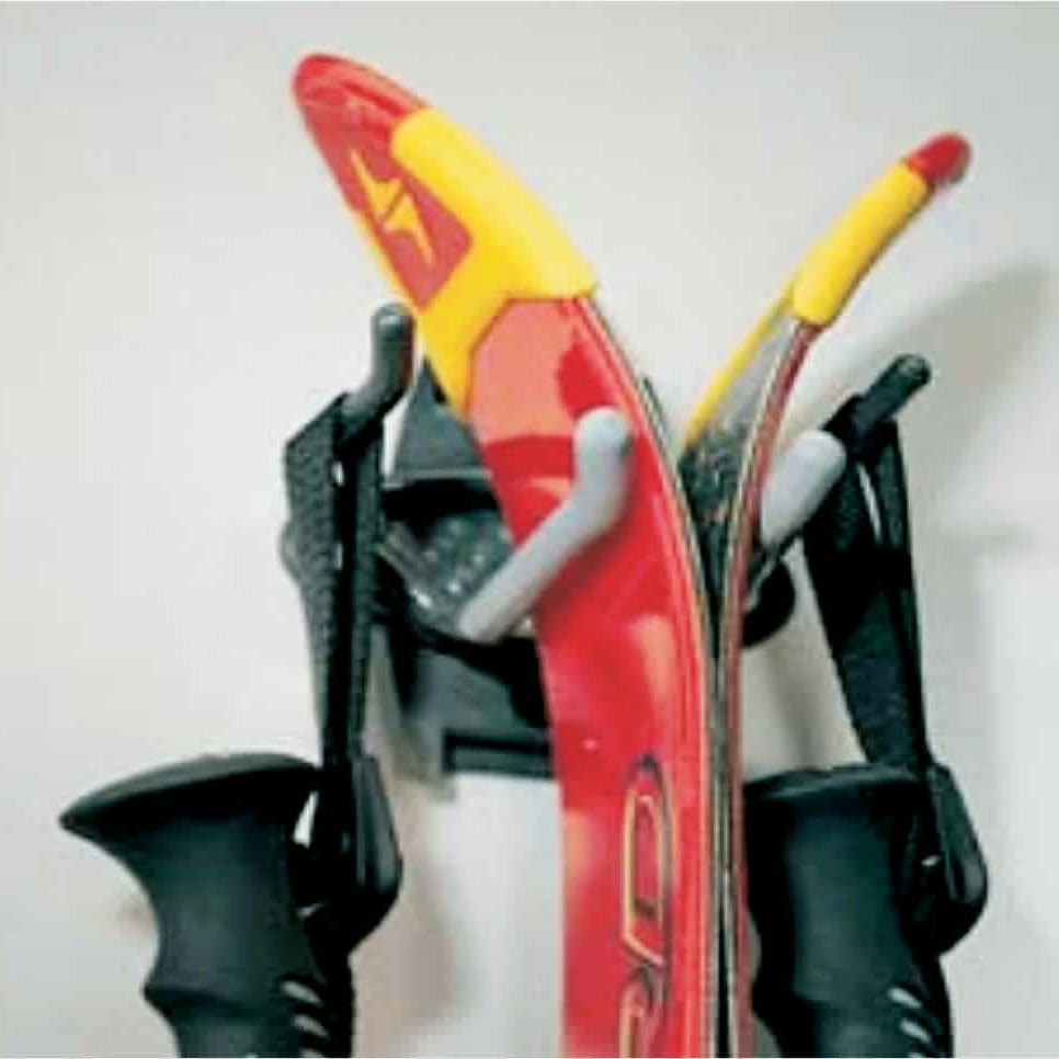 A pair of red skis and poles rest on the RackZone Slatwall Ski Rack.