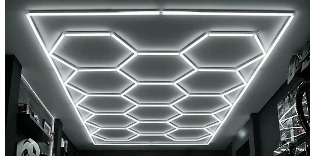 Ceiling with geometric hexagonal LED light fixtures arranged in a grid pattern, creating a modern and futuristic look in the room.