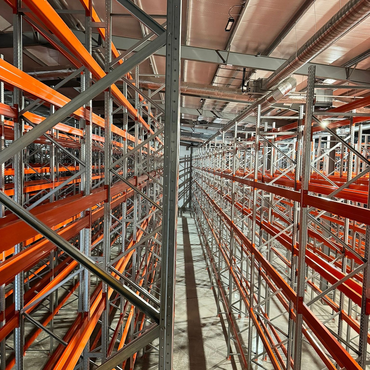 Industrial warehouse with orange metal shelving units.