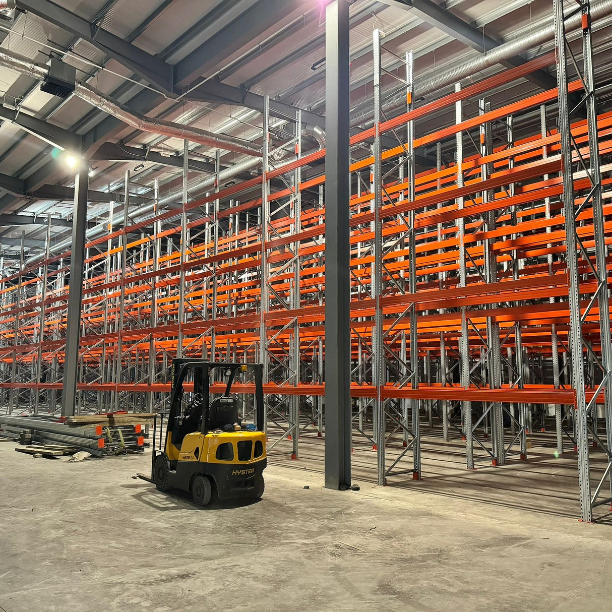 Yellow forklift by empty RackZone Pallet Racking 1100mm Depth - Extender units.