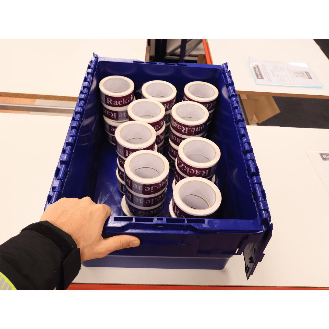 A hand holds a RackZone 44L blue attached lid container with packing tape.