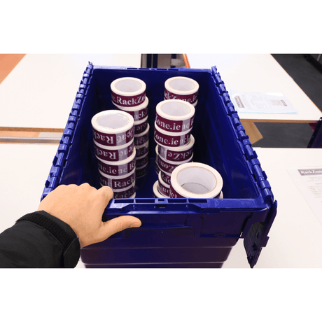 A hand holds a blue RackZone 66L container filled with packaging tape rolls.