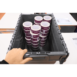A hand holds a RackZone 66L grey attached lid container with printed tape.