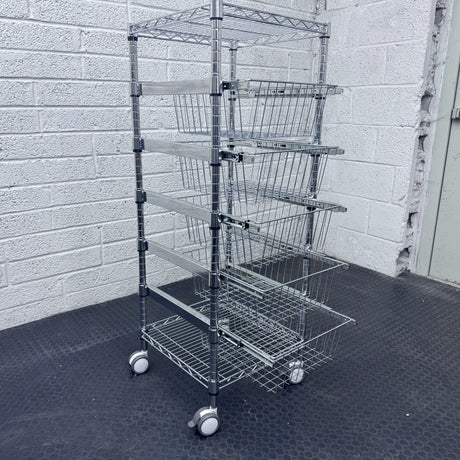 RackZone 5 Tier Chrome Plated Basket Trolley stores items by a gray brick wall.