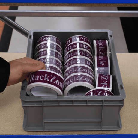 A hand holds a RackZone tape label for Euro Container 400d x 300w x 120h.
