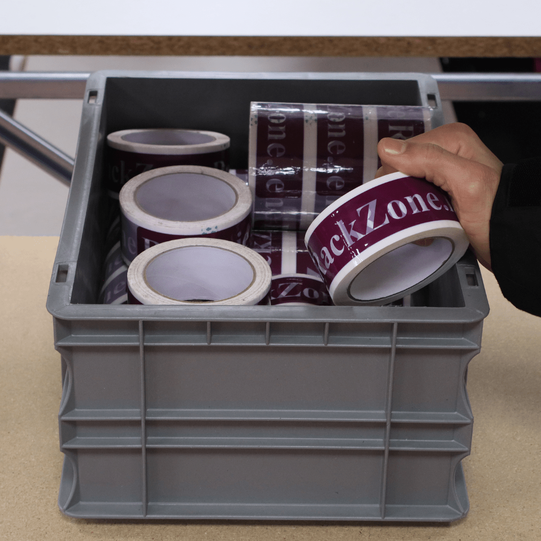 A hand picks up a tape roll from a RackZone Euro Container 400x300x175.