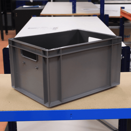 A RackZone Euro Container 400x300x220mm Grey sits on a wooden table.