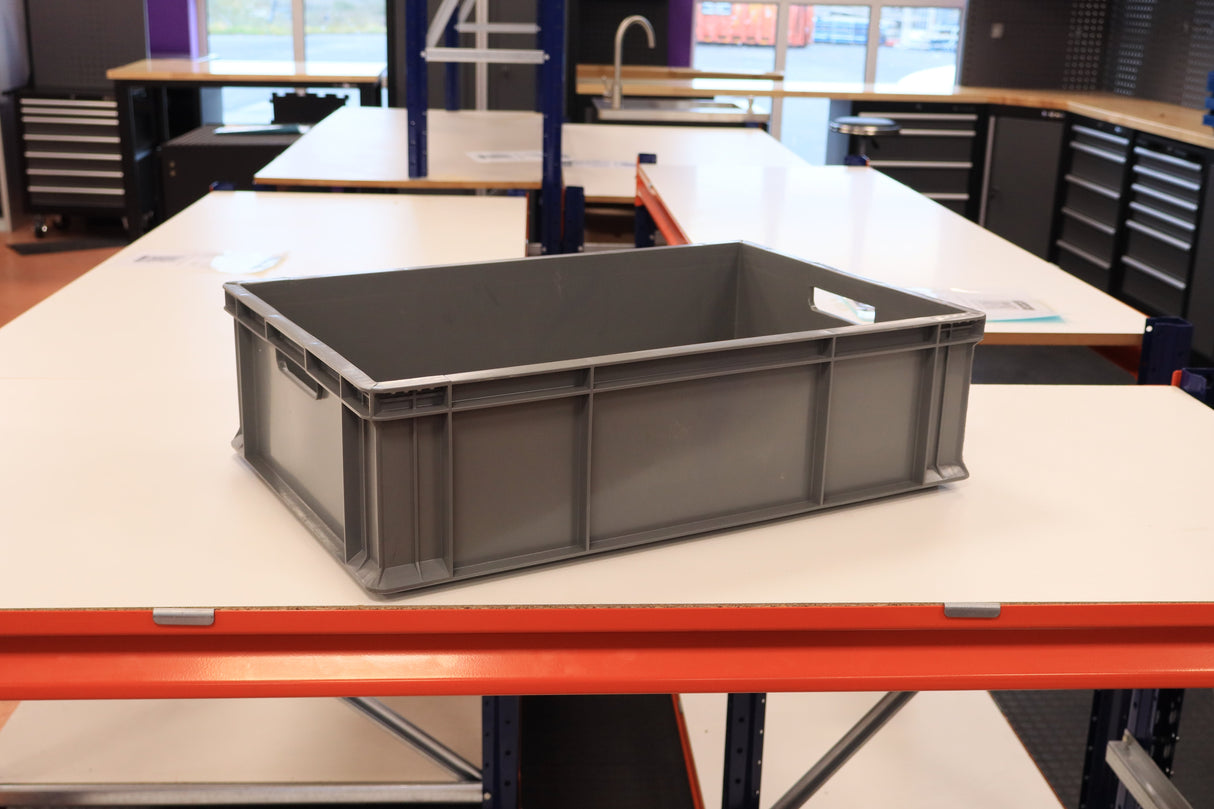 A RackZone grey Euro Container rests on a white workbench in the workshop.