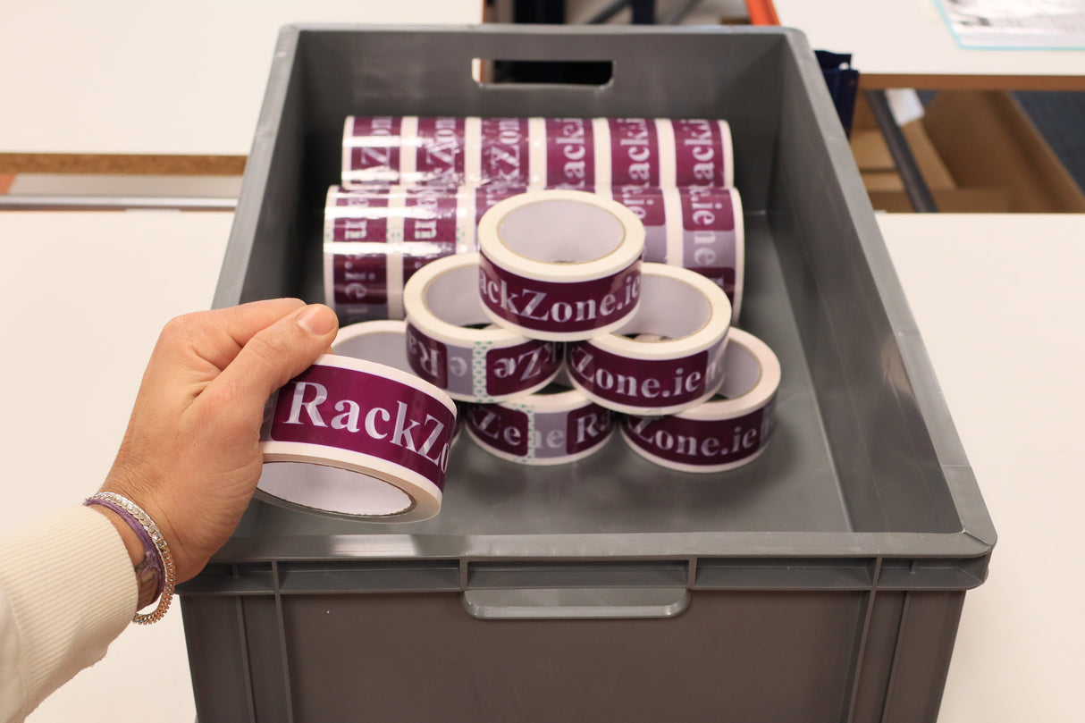 A hand holds a "RackZone" container over stacks of Pallet Deal Euro Containers.