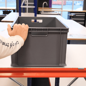 A person places a hand on a RackZone Euro Container 600x400x280mm Grey.