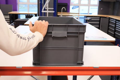 A person holds a RackZone Euro Container 600x400x320mm in a workshop.