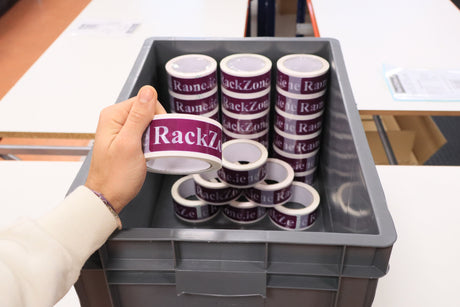 A hand holds RackZone tape above a Pallet Deal 45 Euro Container in grey.