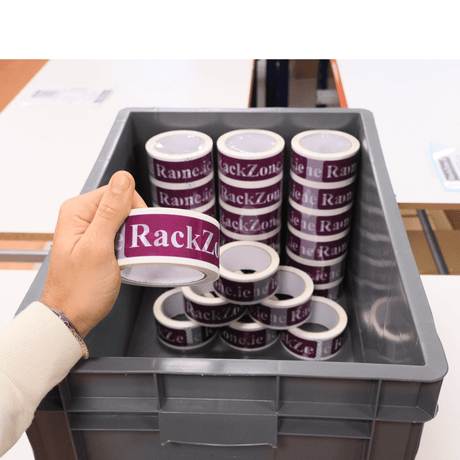 A hand holds RackZone’s Euro Container 600x400x320mm Grey above storage bins.