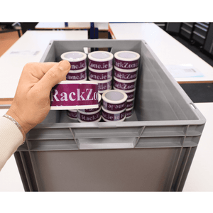 Hand holding a RackZone Euro Container 600x400x340mm Grey above storage rolls.