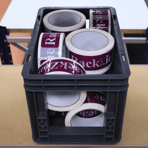 A RackZone Euro Picking Container holds packing tape rolls on a table.