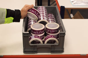 A person stores RackZone tape in a grey Euro Picking Container.