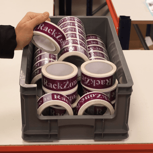 A hand holds "RackZone" Euro Picking Container above a box of storage bins.