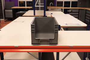 A RackZone grey Euro Picking Container sits on a white workbench.