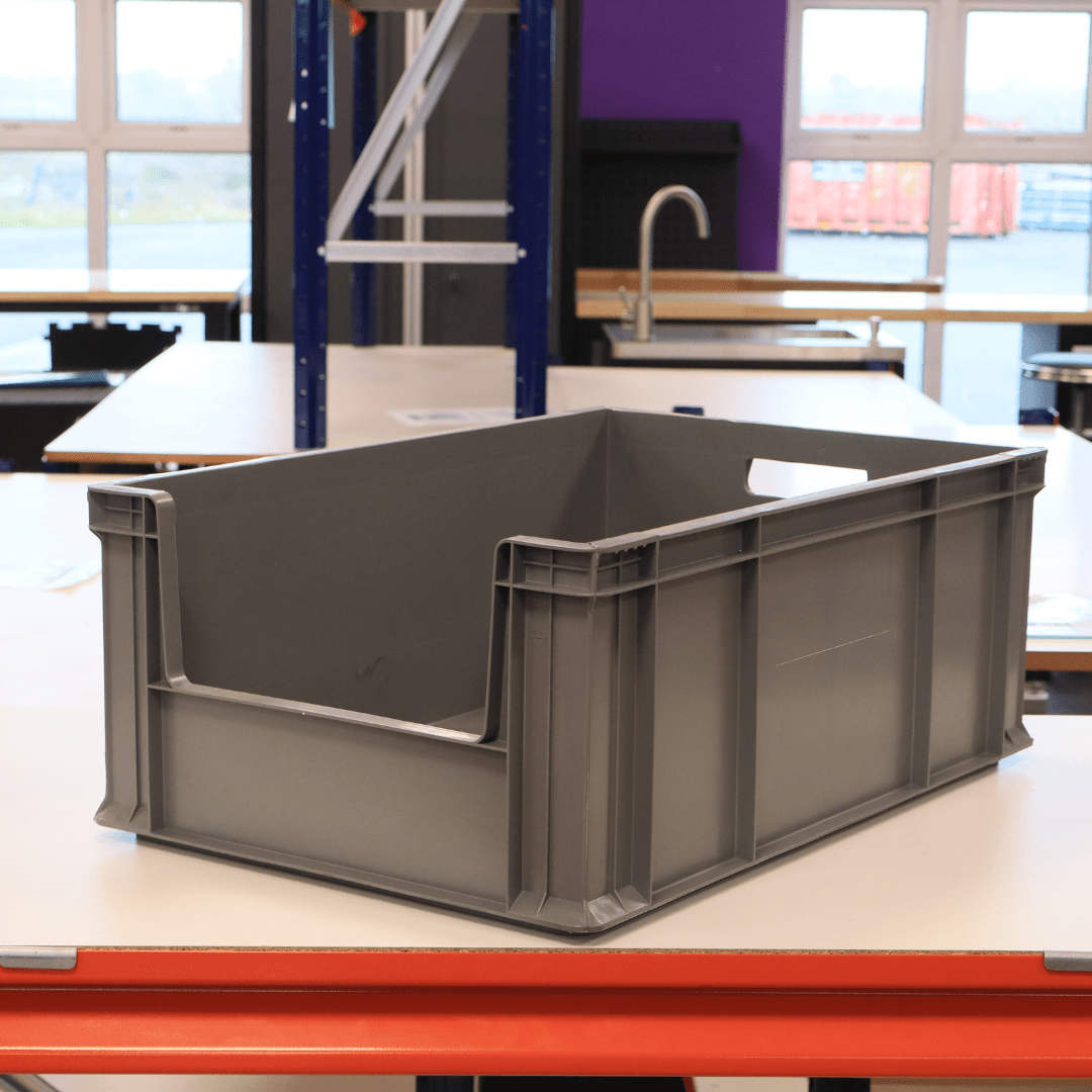 A RackZone Euro Picking Container 600x400x230 Grey sits on a workshop table.