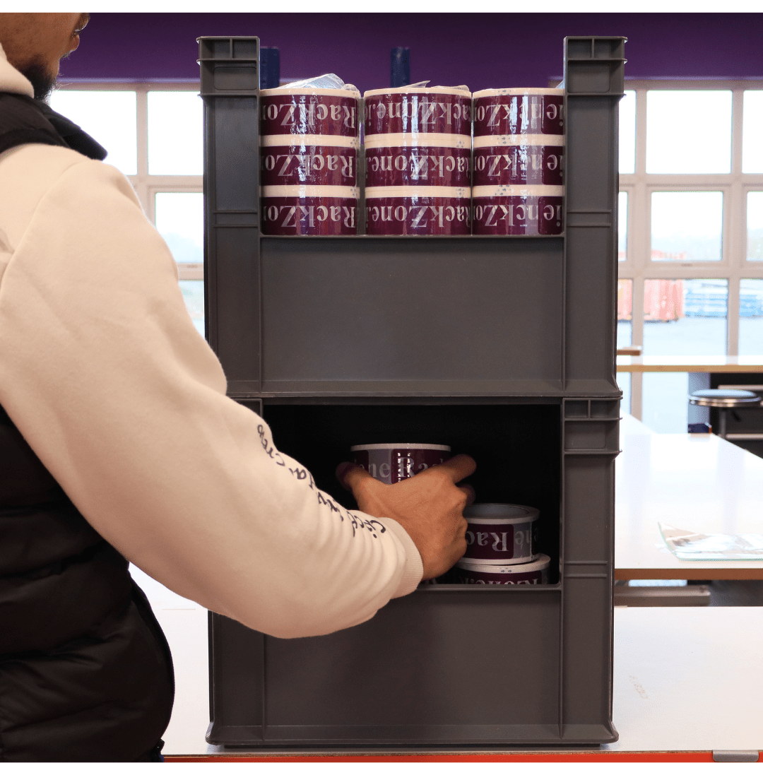 Person placing RackZone Euro Picking Container 600x400x280mm Grey on shelf nearby.