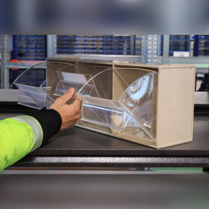 Someone opens a RackZone Tilt Bin Madia 5 on a beige storage unit in a warehouse.