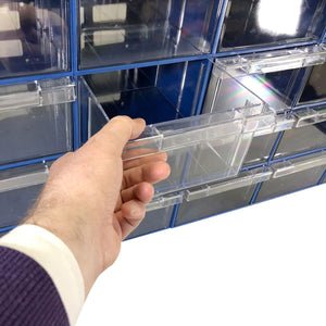 A hand pulls out a RackZone Plastic Drawer 24 Box Blue from a wall organizer.