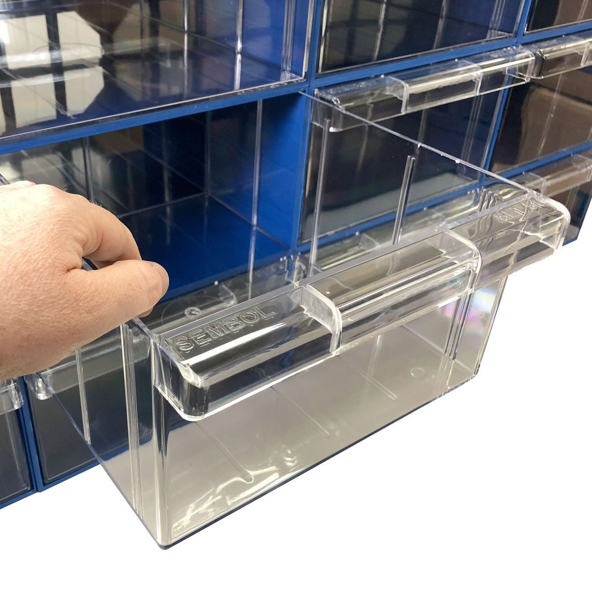 A hand pulls out a RackZone Plastic Drawer 12 Box Blue 510 wall organizer.