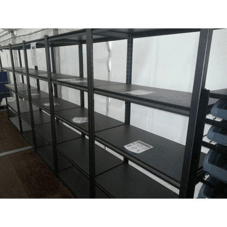 Empty RackZone Rivet Shelving with a few papers on some of the shelves.