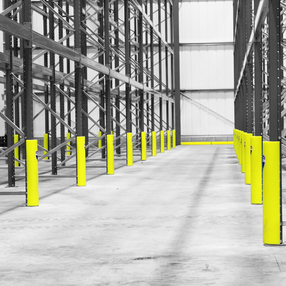 Empty warehouse aisle with RackZone yellow HDPE Upright Protectors on shelving.