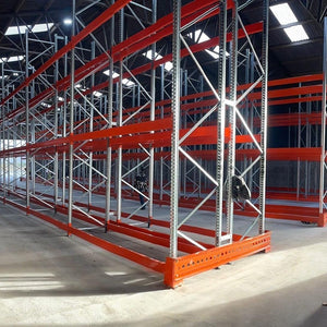 Large warehouse with red and silver metal shelving units.