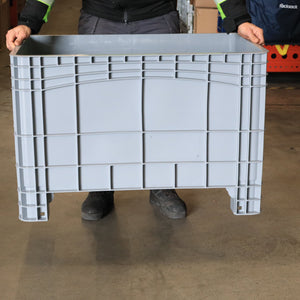 Person holding a RackZone Stacking Container 984d x 625w x 665h Grey indoors.