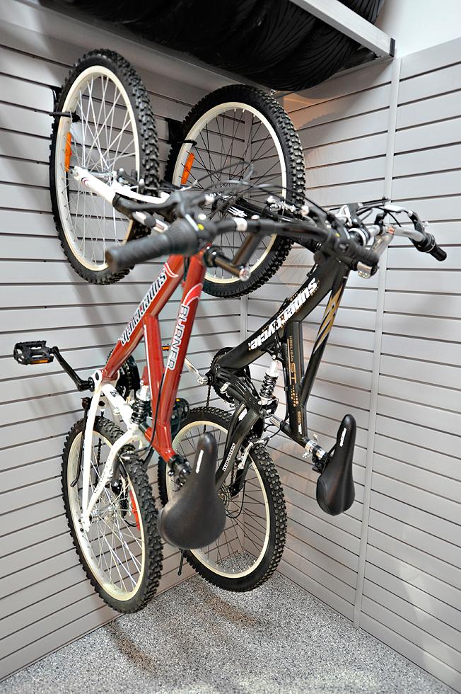 Two mountain bikes hang on RackZone Slatwall PVC Panel in a garage.