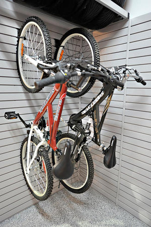 Two mountain bikes hang on RackZone Slatwall PVC Panel in a garage.