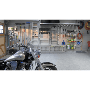 A motorcycle in a clean garage with organized tools and RackZone Slatwall PVC panels.