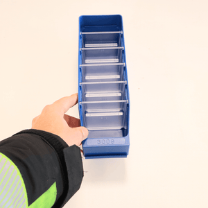 A hand holds a RackZone Standard Shelf Bin ST3009 blue, 300x90x95mm, with dividers.