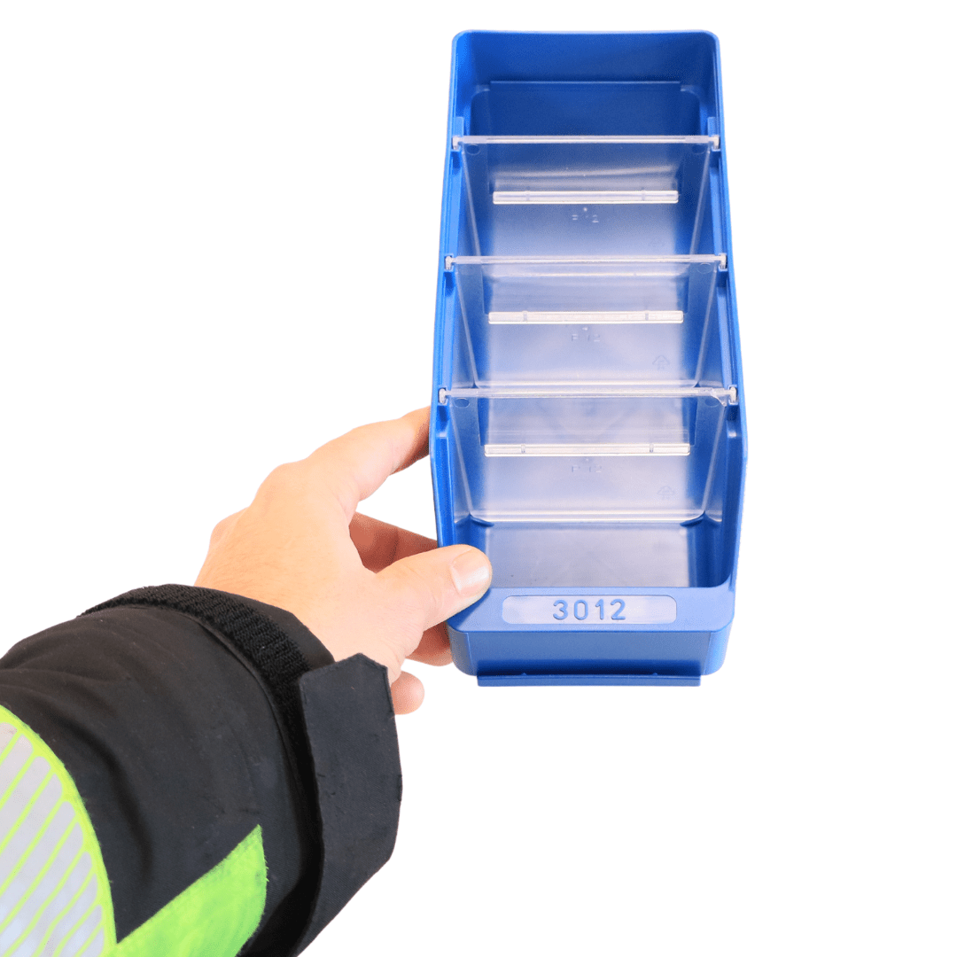 A hand holds a blue RackZone Standard Shelf Bin ST3012 with four divider sections.