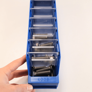 A hand holds a RackZone Standard Shelf Bin ST4009 with metal bolts inside.