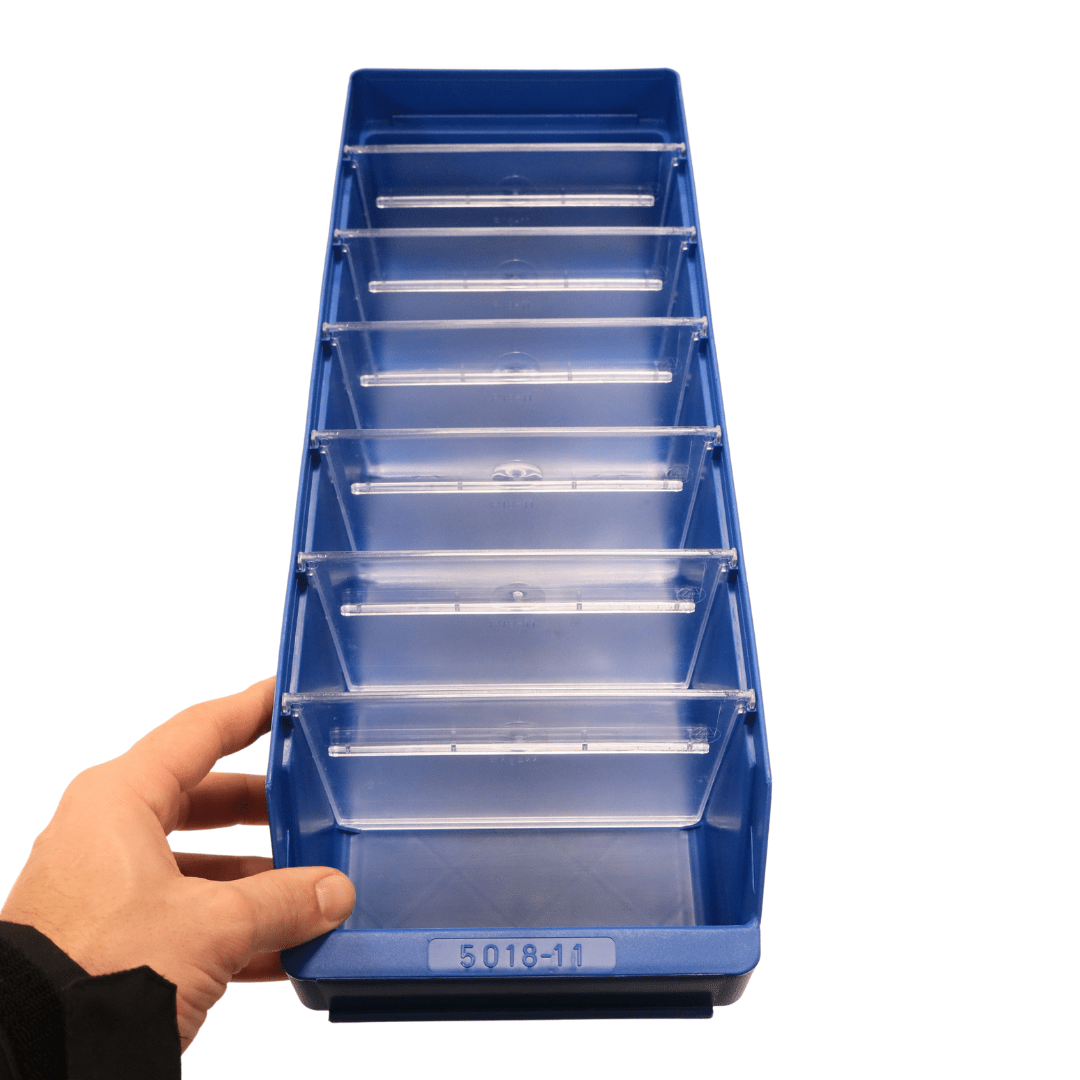 A hand holds a RackZone blue shelf bin ST5018-11 with seven clear dividers.